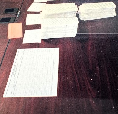 A close up of used punch cards stacked on tables waiting to be reviewed as a part of the 2000 election recount.